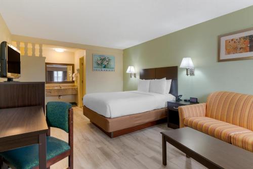 a hotel room with a bed and a couch at University Inn and Suites Eugene in Eugene