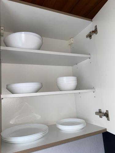 dos tazones blancos en estanterías en una cocina en 2- Zimmer Wohnung, en Lehrte