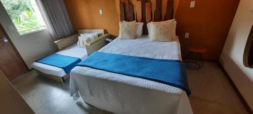 a small bedroom with two beds and a window at Pousada Carapeba in São Francisco