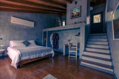 a bedroom with blue walls and a bed and a staircase at Quinta Camarena in Cercal