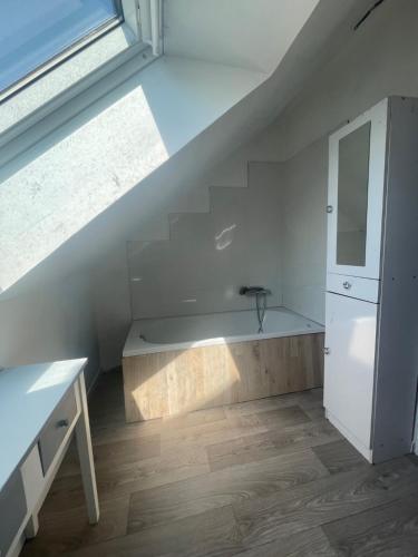 ein Bad unter der Treppe mit einem Waschbecken und einem Spiegel in der Unterkunft Duplex 4 personnes, ARMADA 2023 in Boos