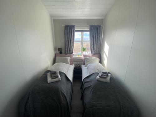 three beds in a room with a window at Skalarimi - Country House in Selfoss