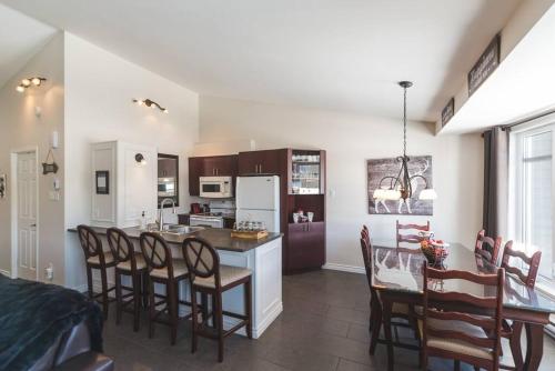 a kitchen and dining room with a table and chairs at Le Bionick 46 (CITQ 312093) in Stoneham