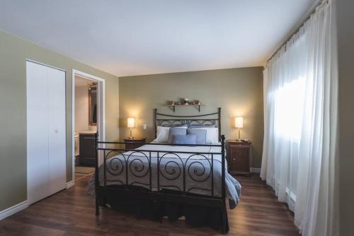1 dormitorio con 1 cama grande con almohadas blancas en Le Bionick 46 (CITQ 312093), en Stoneham