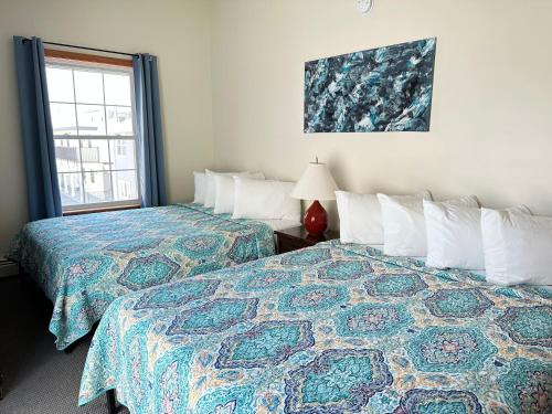 a hotel room with two beds and a window at Abellona Inn & Suites in Old Orchard Beach