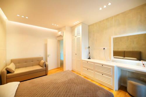 a bedroom with a couch and a sink and a mirror at Villa White Pearl in Palasë