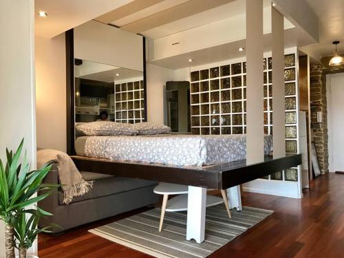 - une chambre principale avec un lit et un miroir dans l'établissement Nice ouest- Studio Vue Mer Garage Piscine WIFI, à Nice