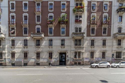 een groot gebouw met auto's geparkeerd voor het bij Stradivarius House - Carozzi Apartments in Milaan