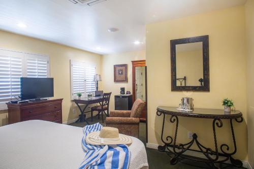a bedroom with a bed and a mirror and a living room at Castillo Inn at the Beach in Santa Barbara