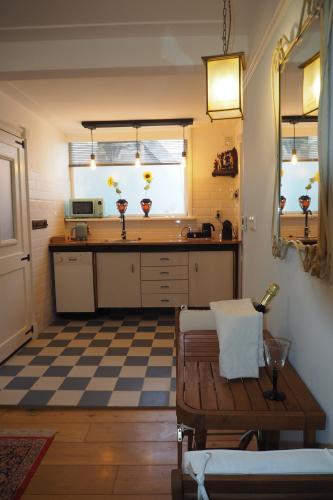 a kitchen with a counter and a table in a room at B&B Bureau Warmoesstraat in Den Burg