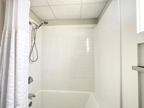 a white bathroom with a tub and a shower at Abellona Inn & Suites in Old Orchard Beach