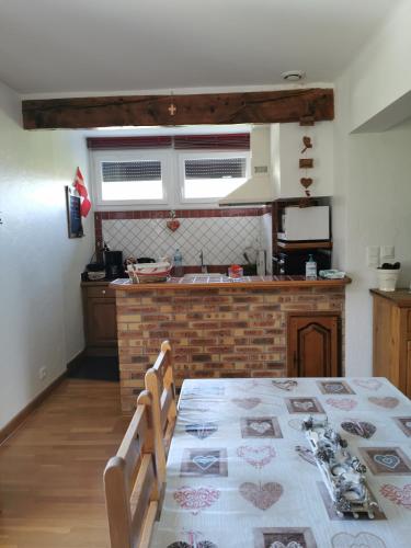 eine Küche mit einem Tisch und eine Küche mit einer Theke in der Unterkunft Josette et Gérald BOTTERI in Saint-Jorioz