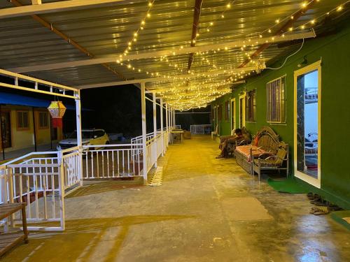 a covered porch with lights on a green building at Green Fog Guesthouse in Lonavala