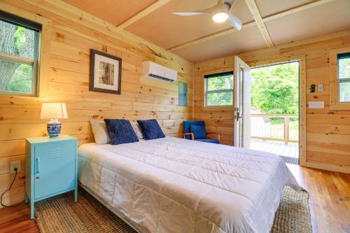 a bedroom with a bed in a room with wooden walls at Cozy Hikers Hideaway Steps From Creeper Trail! in Damascus