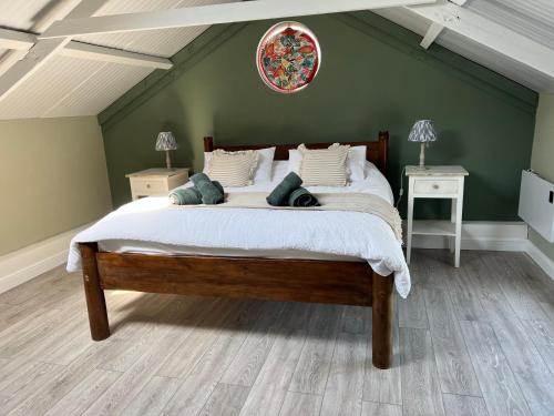 a bedroom with a large bed in a green wall at The Old Water Works - Flat 1 in Wadebridge