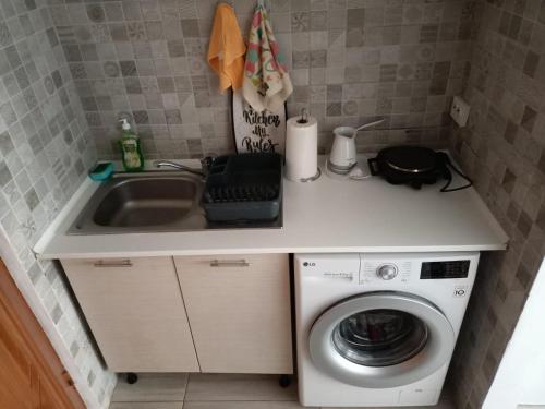 a kitchen with a sink and a washing machine at Peninsula-Cazino,Dalvi in Constanţa