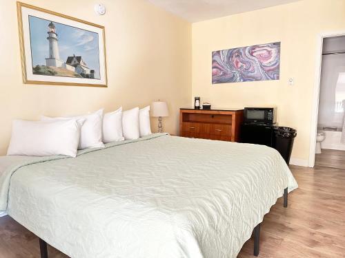 a bedroom with a large white bed with a lighthouse at Abellona Inn & Suites in Old Orchard Beach