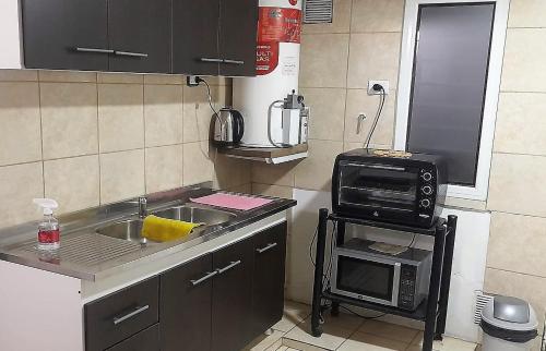 una pequeña cocina con fregadero y microondas en Pellegrini Departamentos muy confortable y bien ubicado en Godoy Cruz