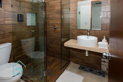 y baño con aseo, lavabo y ducha. en VIca Guest House con piscina en la entrada de la Zona Hotelera, en Cancún