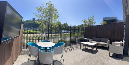 a patio with a table and chairs and a tv at The Landing Hotel at Rivers Casino Pittsburgh in Pittsburgh
