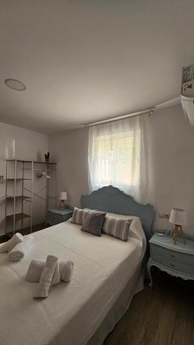 una camera da letto con un grande letto con due cuscini sopra di Apartamento Adriano a Santiponce