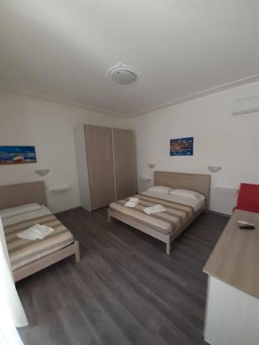 a room with two beds and a red couch at La Llua Alghero in Alghero