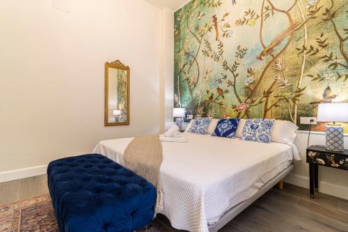 a bedroom with a bed and a painting on the wall at Casa Palacio Rufina & Jardines in Jerez de la Frontera