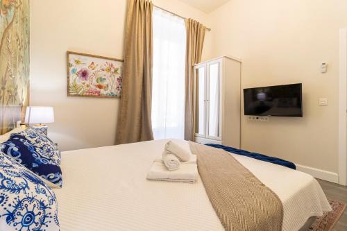 a bedroom with a white bed and a window at Casa Palacio Rufina & Jardines in Jerez de la Frontera