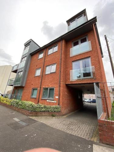 een gebouw van rode baksteen met een garage bij Lovely studio apartment in Norwich city centre in Norwich