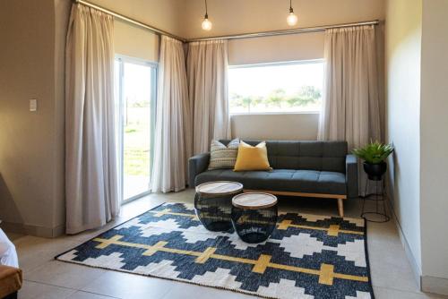 a living room with a couch and a rug at Summer PALACE Guesthouse in Bloemfontein