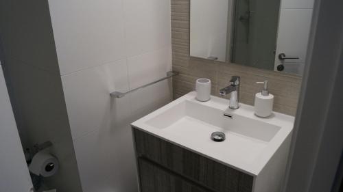 y baño con lavabo blanco y espejo. en Departamento El Chiriwe, en Puerto Varas