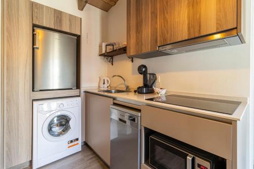 a small kitchen with a washer and dryer at Casa Palacio Rufina & Jardines in Jerez de la Frontera