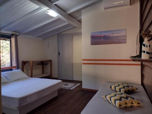 Un dormitorio con una cama y una mesa. en Casas Porto Belo, um recanto a 100 metros da praia, en Porto Belo