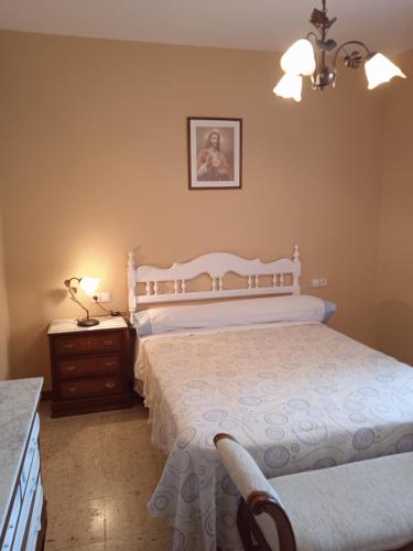 um quarto com uma cama branca, uma cómoda e uma mesa de cabeceira. em Tío Moncho - Casa Tía María em Vilanova de Arousa