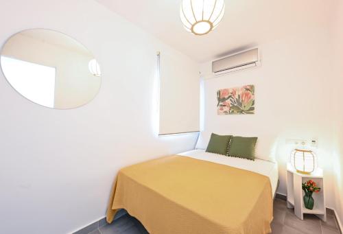 mała sypialnia z łóżkiem i lustrem w obiekcie Belgica 2 - 2 room city & beach by 10ToSea w mieście Fuengirola