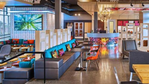 a restaurant with colorful chairs and tables in a room at Aloft Chesapeake in Chesapeake