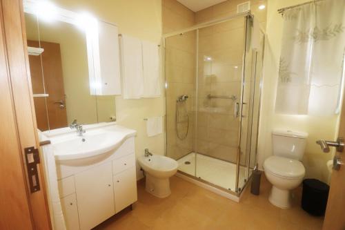 uma casa de banho com um lavatório, um chuveiro e um WC. em Casa dos Meoes no Gerês