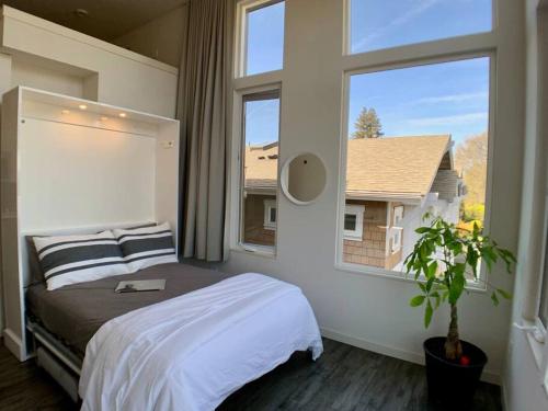 ein Schlafzimmer mit einem Bett und einem großen Fenster in der Unterkunft Lofty Studio Prime Cap Hill Area Mins to Downtown in Seattle