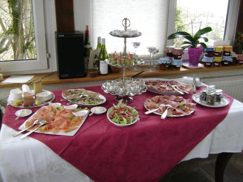 Una mesa cubierta con platos de comida sobre una mesa. en Les Petunias, en Hugier