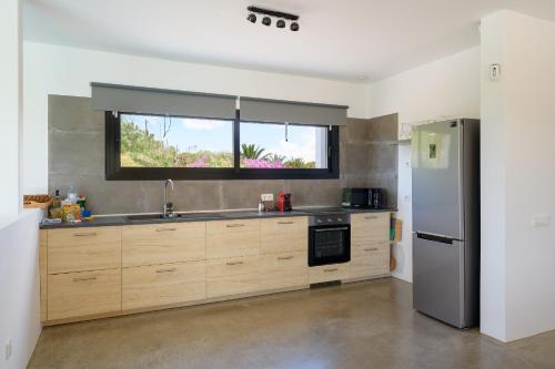 a kitchen with a stainless steel refrigerator and a window at Casa Sur, Conil in Conil