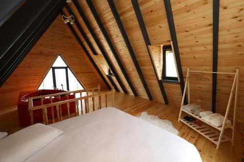 a bedroom in a wooden cabin with two beds at Azhara Bungalov in Pelitli