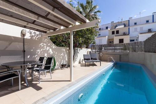 a patio with a table and chairs next to a pool at BmyGuest - Vilamoura Marina's View in Vilamoura