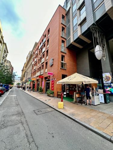 an empty city street with a building and an umbrella at Central apartment with balcony in Budapest