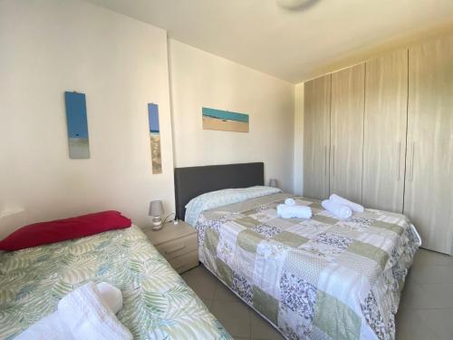 two beds in a small room with blue pictures on the wall at Venere Apartament in Tirrenia