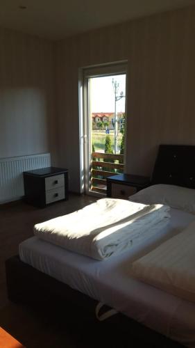 a bedroom with two beds and a window at Dom Apart Magda Rewal in Rewal