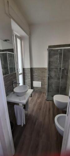 a bathroom with two sinks and a shower and two toilets at La Llua Alghero in Alghero