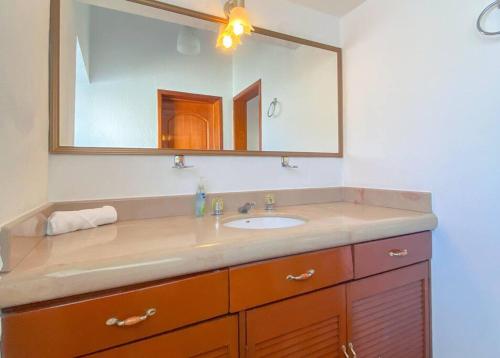 un baño con lavabo y espejo en Casa Yemina Alberca y Asador Privados., en Puerto Vallarta