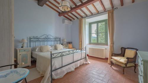 una camera con un letto e una sedia e una finestra di Vallibona 10 a Castiglion Fiorentino