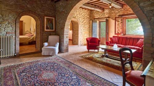 ein Wohnzimmer mit einem roten Sofa und einem Tisch in der Unterkunft Casale Conte Jacopo 10 in Magione