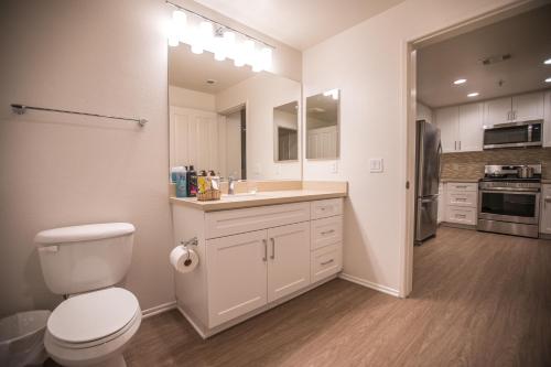 a white bathroom with a toilet and a sink at Irvine Spectrum/2 Bedrooms/2 Bathrooms/Apartment/pool/gym in Irvine